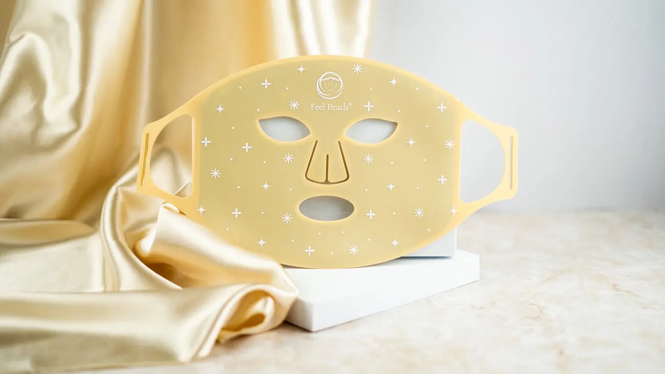 LED masku Feel Pearls so svetelnou terapiou, ktorá transformuje vašu skincare rutinu a prináša výsledky ako zo salónu priamo do pohodlia vášho domova. Je to jednorazová investícia, ktorá sa vám rýchlo vráti, a pleť si ošetríte už za 10 minút. Produkt je certifikovaný a dermatologicky testovaný, balenie je ekologické a vzťahuje sa naň 30-dňová garancia vrátenia peňazí. Podľa Jany, spokojnej zákazníčky, je maska „výborná“, keďže za pár minút máte hotovú celú skincare rutinu bez návštevy salónu. Ako funguje svetelná terapia LED masky? LED svetlo z masky preniká do hlbších vrstiev pokožky vďaka svojej vlnovej dĺžke, kam bežné kozmetické produkty nepreniknú. Stimuluje bunky, podporuje tvorbu kolagénu, zlepšuje cirkuláciu a regeneráciu kože. Fotónová terapia je vedecky dokázaná, nespôsobuje žiadne vedľajšie účinky ani poškodenie organizmu a je úplne bezbolestná. Farby svetla a ich špecifické účinky: LED maska ponúka rôzne vlnové dĺžky svetla, z ktorých každá má špecifické benefity pre vašu pleť: • Blízke infračervené (830 nm) + Červené svetlo (630 nm): ◦ Preniká do hĺbky 5-10 mm do pokožky. ◦ Podporuje krvný obeh a produkciu kolagénu, čím spevňuje a vyhladzuje pleť. ◦ Výrazne stimuluje prirodzený proces obnovy kože. ◦ Pomáha zmierňovať jazvy, spevňovať pleť a vyhladzovať jemné vrásky. • Modré svetlo (465 nm): ◦ Aktivuje porfyríny, ktoré ničia škodlivé baktérie. ◦ Má silný antibakteriálny a protizápalový účinok. ◦ Efektívne pôsobí ako prevencia proti tvorbe akné. • Zelené svetlo (515 nm): ◦ Upokojuje pokožku a zrýchľuje jej hojenie. ◦ Zosvetľuje pleť a prispieva k zjednoteniu jej tónu. • Žlté svetlo (630 + 515 nm): ◦ Kombinácia červeného a zeleného svetla. ◦ Prispieva k zlepšeniu bunkového metabolizmu. ◦ Zlepšuje problémy spojené s mastnou pleťou a čiernymi bodkami. ◦ Eliminuje pigmentové škvrny a spomaľuje starnutie kože. • Tyrkysové svetlo (515 + 460 nm): ◦ Kombinácia zeleného a modrého svetla. ◦ Pôsobí antibakteriálne a protizápalovo, čím pomáha predchádzať akné. • Fialové svetlo (630 + 460 nm): ◦ Kombinácia červeného a modrého svetla. ◦ Výrazne stimuluje prirodzený proces obnovy kože. ◦ Zmierňuje jazvy, spevňuje pleť, vyhladzuje jemné vrásky. ◦ Má antibakteriálny a protizápalový účinok. • Biele svetlo (630 + 515 + 460 nm): ◦ Kombinácia červeného, zeleného a modrého svetla. ◦ Stimuluje prirodzený proces obnovy kože, zmierňuje jazvy, spevňuje pleť a vyhladzuje jemné vrásky. ◦ Má antibakteriálny a protizápalový účinok. Ako sa LED maska používa? Pre optimálne výsledky a bezpečnosť dodržujte nasledujúce kroky: 1. Test senzibilizácie: Pred prvým ošetrením umiestnite masku na vnútornú stranu predlaktia, zapnite ju a nechajte prejsť celý 10-minútový program. Ak pocítite horúčavu alebo nepríjemné pocity, okamžite masku vypnite. Ak sa po 6 hodinách objaví začervenanie alebo svrbenie, maska nemusí byť vhodná. 2. Príprava pleti: Používajte masku na dôkladne vyčistenú a suchú pleť. 3. Intenzita a dĺžka ošetrenia: Začnite s intenzitou stupňa 1-2, aby si pokožka zvykla. Odporúča sa používať LED masku 3-5 krát týždenne, pričom každé ošetrenie by malo trvať 10-20 minút. Prístroj sa po zvolenom intervale automaticky vypne. Modré svetlo sa odporúča používať maximálne 10 minút denne. 4. Starostlivosť po terapii: Po LED terapii pokračujte s vašou klasickou skincare rutinou. Účinné látky z kozmetických produktov sa lepšie vstrebú do pokožky po takejto terapii. Pre koho je LED maska vhodná a kedy je potrebná opatrnosť? LED maska je vhodná pre všetky typy pleti. Prístroj je určený pre osoby staršie ako 12 rokov. Opatrnosť a konzultácia s lekárom je potrebná pri užívaní liekov alebo steroidov proti bolesti či iným kožným ochoreniam, pretože použitie masky môže spôsobiť fotosenzitívnu reakciu. Onkologickí pacienti môžu LED terapiu používať len po konzultácii so svojím doktorom. Maska nie je vhodná pre: tehotné a dojčiace ženy, osoby trpiace epilepsiou, silnou migrénou, precitlivenosťou na svetlo, alebo pre aplikáciu na otvorené rany, spálenú pokožku po opaľovaní či na dotyk bolestivú pleť. Technické parametre a balenie: • Hlavný materiál: ABS plast + silikón • Rozmer masky: 380x200x3 mm • Batéria: 1500mAh 5V/1A • Svetelný výkon: Nadštandardný výkon až 60mW/cm2, s 3 stupňami intenzity. Dáva to maske o polovicu vyšší výkon než väčšina domácich LED masiek na trhu. • Časovač: 10/15/20 minút • Počet LED diód: 100 ks • Nabíjanie: Plné nabitie ovládača/adaptéra trvá 90-100 minút, maska vydrží svietiť približne 40 minút pri najvyššej intenzite. Obsah balenia: Balenie obsahuje LED masku, ovládač na pripojenie, ochranu na oči, manuál v slovenskom jazyku, nabíjací kábel a cestovné vrecko